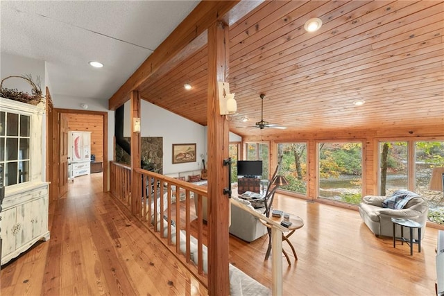 hall with vaulted ceiling, light wood-type flooring, and wood ceiling