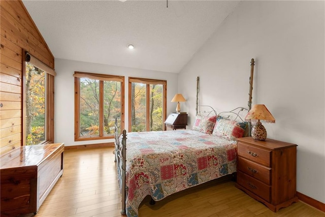 bedroom with vaulted ceiling and light wood-type flooring