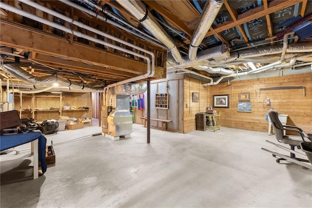 basement with heating unit and wood walls