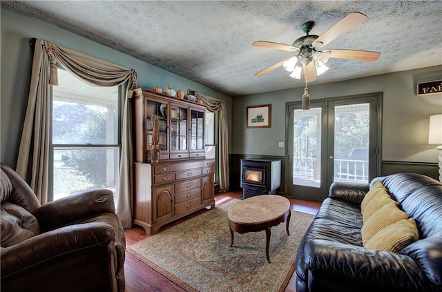 90 Wiley Dr, Douglasville, GA 30134 - living room featuring a wood stove, a textured ceiling, wood finished floors, ceiling fan, and french doors