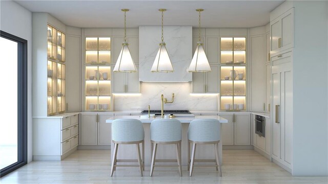 kitchen with light hardwood / wood-style flooring, decorative light fixtures, tasteful backsplash, paneled built in fridge, and a center island