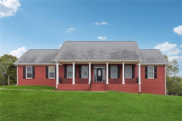 view of front facade featuring a front lawn, roof with shingles, and brick siding