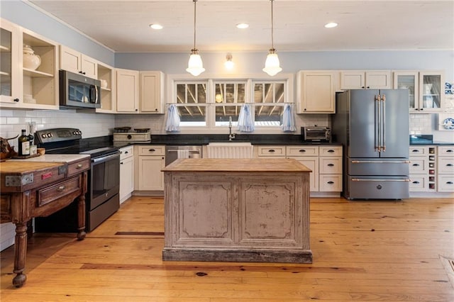 527 Main St, Suwanee, GA 30024 - kitchen featuring appliances with stainless steel finishes, decorative backsplash, a kitchen island, open shelves, and glass insert cabinets
