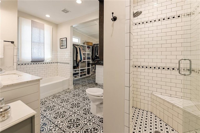 527 Main St, Suwanee, GA 30024 - bathroom with tile walls, a shower stall, a bath, vanity, and recessed lighting