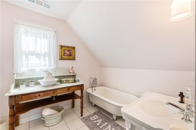 527 Main St, Suwanee, GA 30024 - bathroom with a freestanding tub, vaulted ceiling, vanity, and tile patterned floors