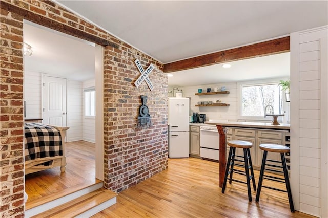 527 Main St, Suwanee, GA 30024 - kitchen with light wood finished floors, plenty of natural light, white dishwasher, open shelves, and brick wall