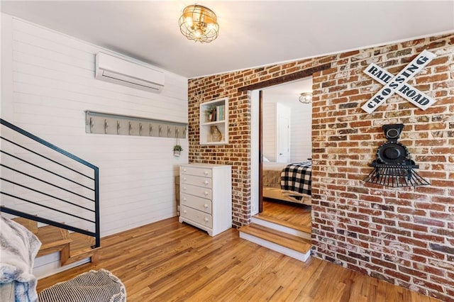 527 Main St, Suwanee, GA 30024 - entrance foyer with an AC wall unit, wood-type flooring, a wood stove, stairs, and brick wall