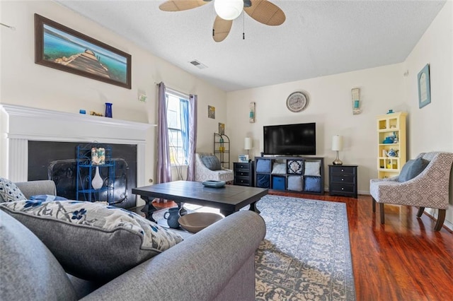 living room featuring ceiling fan and dark hardwood / wood-style flooring