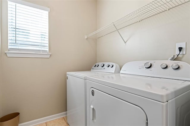 laundry room with independent washer and dryer and light tile patterned floors