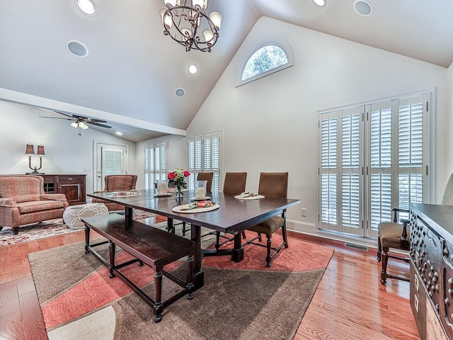 dining room with high vaulted ceiling, recessed lighting, ceiling fan with notable chandelier, wood finished floors, and visible vents