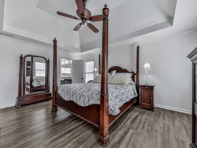 bedroom with dark wood-style floors, baseboards, visible vents, and a raised ceiling