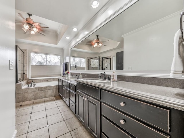 full bathroom featuring a raised ceiling, a ceiling fan, ornamental molding, a garden tub, and tile patterned flooring