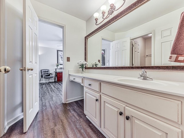 bathroom featuring baseboards, wood finished floors, and vanity