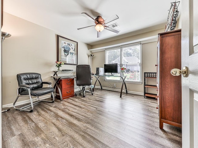 home office with baseboards, visible vents, ceiling fan, and wood finished floors