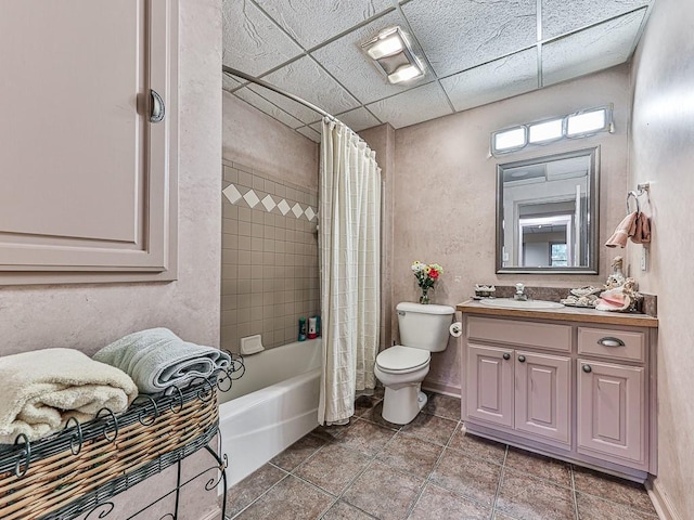 full bathroom featuring toilet, a paneled ceiling, shower / tub combo with curtain, and vanity