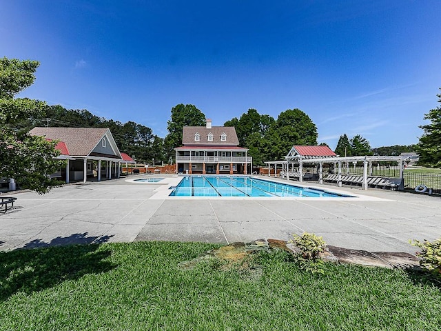 community pool with fence and a hot tub