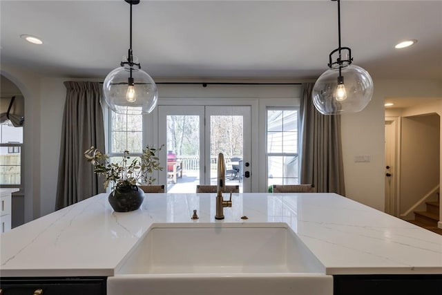 kitchen with a sink, light stone countertops, and recessed lighting