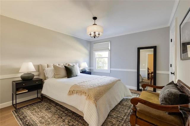 bedroom featuring ornamental molding, baseboards, and wood finished floors