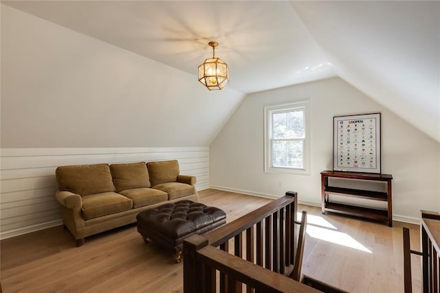 bonus room with vaulted ceiling, light wood-type flooring, and baseboards