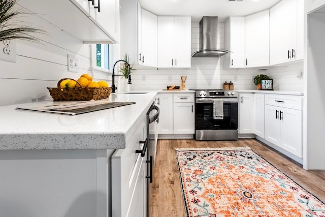 661 Inglewood Dr SE, Smyrna, GA 30080 - kitchen with wall chimney range hood, stainless steel range with electric stovetop, a sink, decorative backsplash, and white cabinets