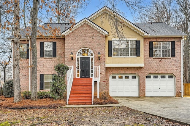 bi-level home featuring driveway, brick siding, an attached garage, and stucco siding