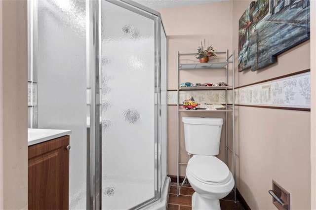 bathroom with a stall shower, toilet, and vanity