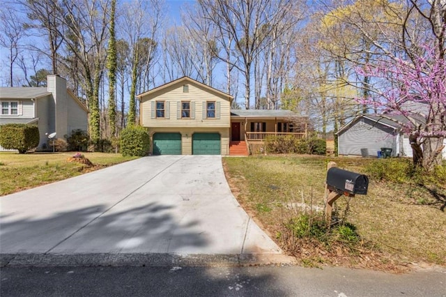 split level home featuring a porch, driveway, a garage, and a front lawn