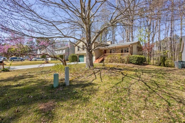 view of front facade featuring a front lawn, a porch, and concrete driveway