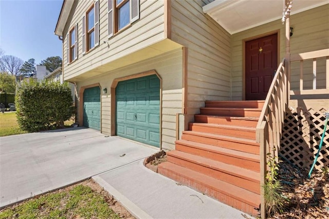 property entrance with an attached garage and concrete driveway