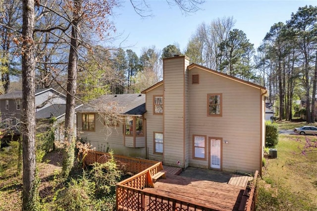 rear view of house featuring a wooden deck and a chimney