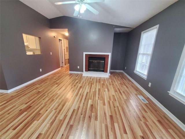 unfurnished living room with vaulted ceiling, light hardwood / wood-style flooring, and ceiling fan