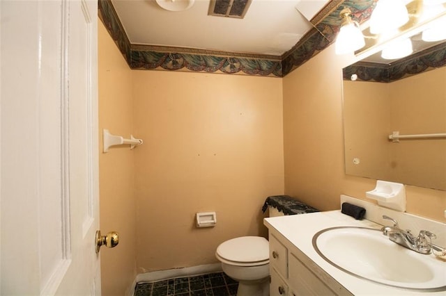 half bath featuring visible vents, toilet, vanity, and baseboards