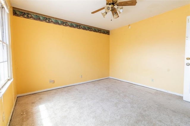 spare room featuring ceiling fan and baseboards