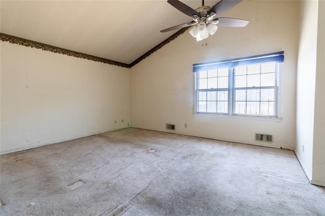 spare room with carpet flooring, visible vents, a ceiling fan, and lofted ceiling