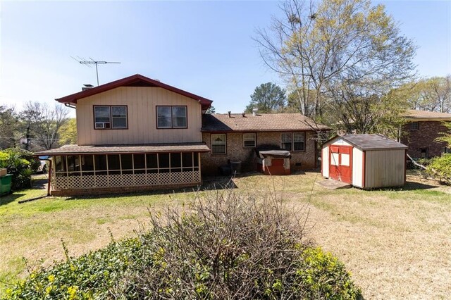 rear view of property featuring a sunroom, an outbuilding, a storage unit, and a lawn