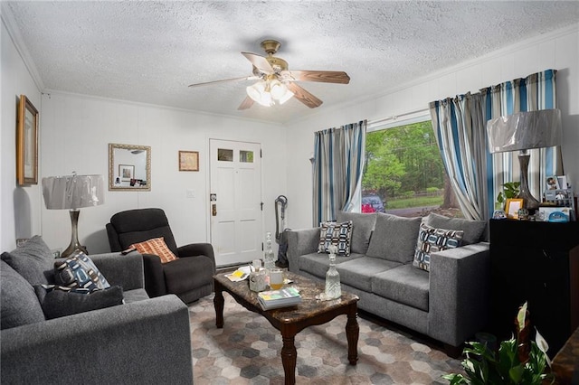 living room featuring ceiling fan, ornamental molding, and a textured ceiling