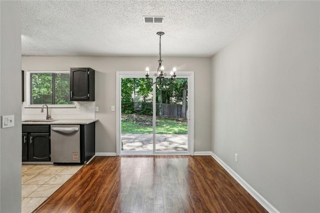 1050 Chapman Cir, Stone Mountain, GA 30088 - kitchen with dishwasher, a chandelier, light countertops, plenty of natural light, and a textured ceiling