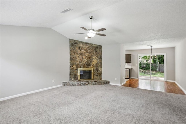 1050 Chapman Cir, Stone Mountain, GA 30088 - unfurnished living room featuring carpet flooring, ceiling fan, vaulted ceiling, a fireplace, and a textured ceiling