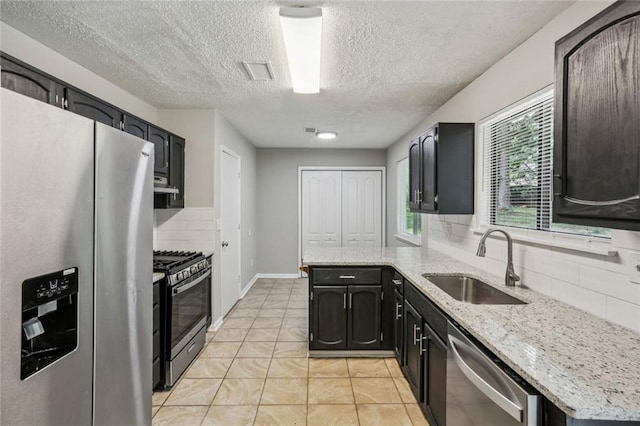 1050 Chapman Cir, Stone Mountain, GA 30088 - kitchen featuring stainless steel appliances, backsplash, a textured ceiling, light tile patterned floors, and light stone counters