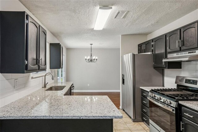 1050 Chapman Cir, Stone Mountain, GA 30088 - kitchen featuring appliances with stainless steel finishes, under cabinet range hood, backsplash, light stone countertops, and a textured ceiling