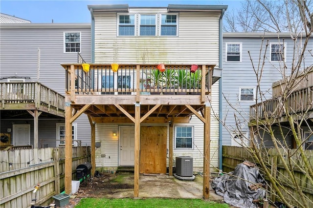 back of house with central air condition unit and a deck