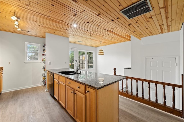 kitchen featuring sink, a center island with sink, dishwasher, dark stone counters, and light hardwood / wood-style floors