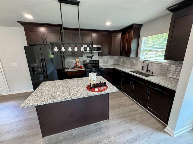 1341 E Atlanta Rd E, Stockbridge, GA 30281 - kitchen featuring black appliances, light wood finished floors, a sink, dark brown cabinetry, and tasteful backsplash