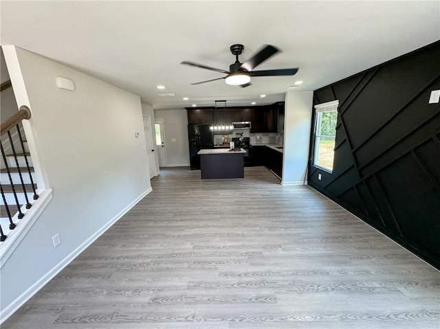 1341 E Atlanta Rd E, Stockbridge, GA 30281 - unfurnished living room featuring a ceiling fan, light wood finished floors, stairs, baseboards, and recessed lighting