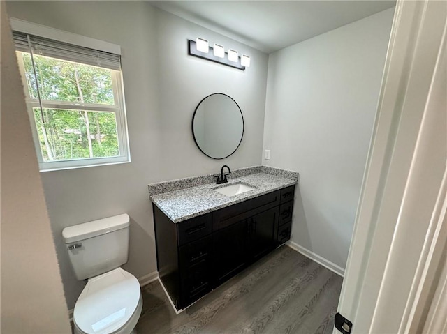 1341 E Atlanta Rd E, Stockbridge, GA 30281 - half bathroom featuring vanity, toilet, wood finished floors, and baseboards