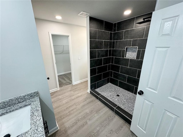 1341 E Atlanta Rd E, Stockbridge, GA 30281 - bathroom with a tile shower, wood finished floors, a walk in closet, vanity, and recessed lighting