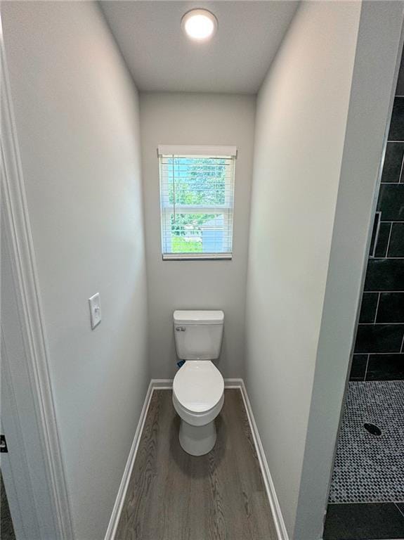1341 E Atlanta Rd E, Stockbridge, GA 30281 - bathroom featuring toilet, a stall shower, wood finished floors, and baseboards