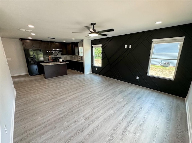 1341 E Atlanta Rd E, Stockbridge, GA 30281 - kitchen with black refrigerator with ice dispenser, open floor plan, a ceiling fan, a kitchen island, and light wood-style floors