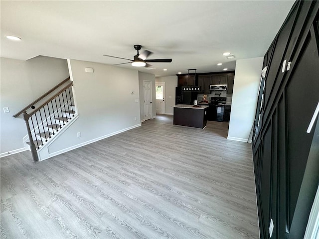 1341 E Atlanta Rd E, Stockbridge, GA 30281 - unfurnished living room with ceiling fan, light wood-type flooring, baseboards, stairway, and recessed lighting
