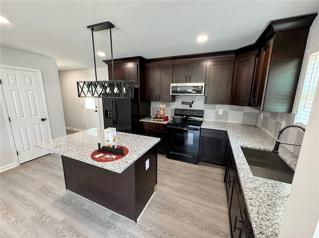 1341 E Atlanta Rd E, Stockbridge, GA 30281 - kitchen with black appliances, a sink, light wood finished floors, dark brown cabinets, and tasteful backsplash